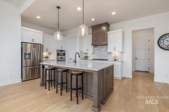 4923 W Canaston St, Meridian, ID 83646 - kitchen featuring appliances with stainless steel finishes, tasteful backsplash, a breakfast bar, light countertops, and a sink