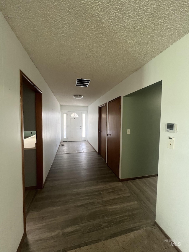 1069 Lucky Ln, Ontario, OR 97914 - corridor with a textured ceiling, dark wood-style flooring, and baseboards