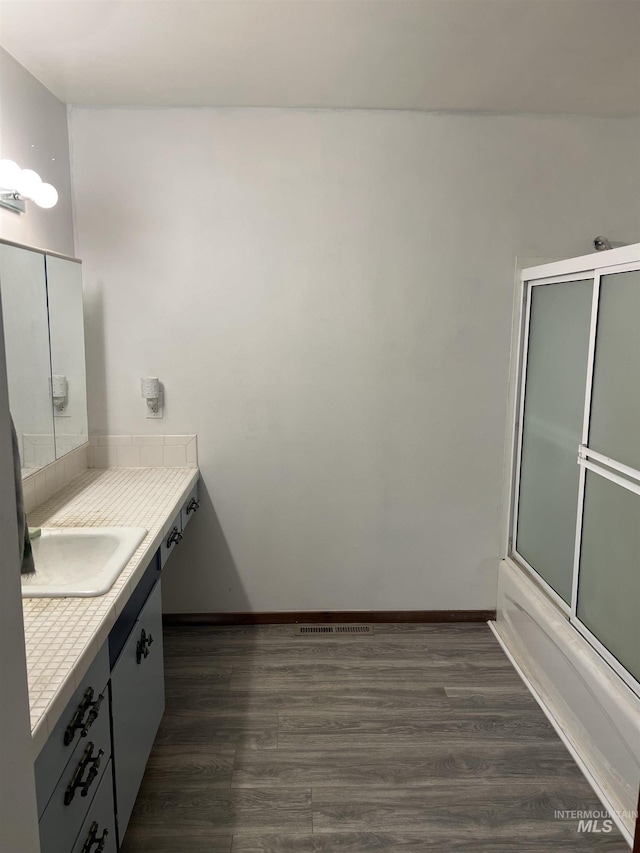 1069 Lucky Ln, Ontario, OR 97914 - full bathroom featuring vanity, wood finished floors, shower / bath combination with glass door, and baseboards
