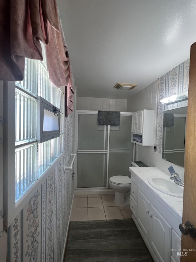 1069 Lucky Ln, Ontario, OR 97914 - full bathroom with wallpapered walls, a shower with door, vanity, toilet, and tile patterned floors