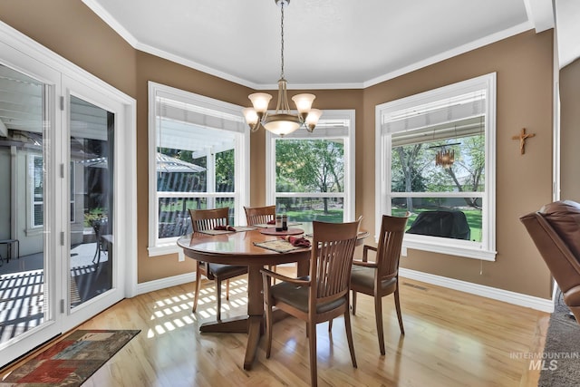 dining area with visible vents, baseboards, light wood finished floors, a chandelier, and ornamental molding