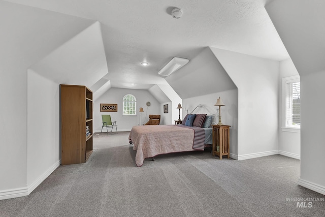 carpeted bedroom with baseboards and lofted ceiling