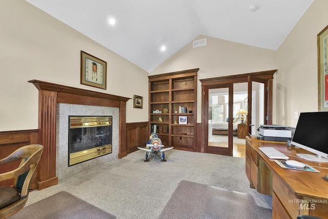 home office with visible vents, a fireplace, a wainscoted wall, french doors, and carpet flooring