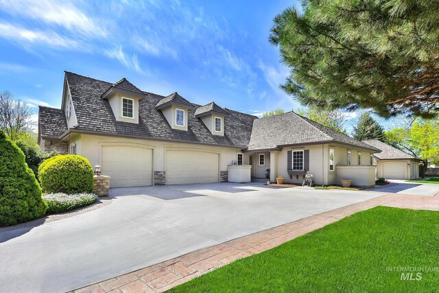 view of front of house featuring an attached garage, stucco siding, driveway, and stone siding