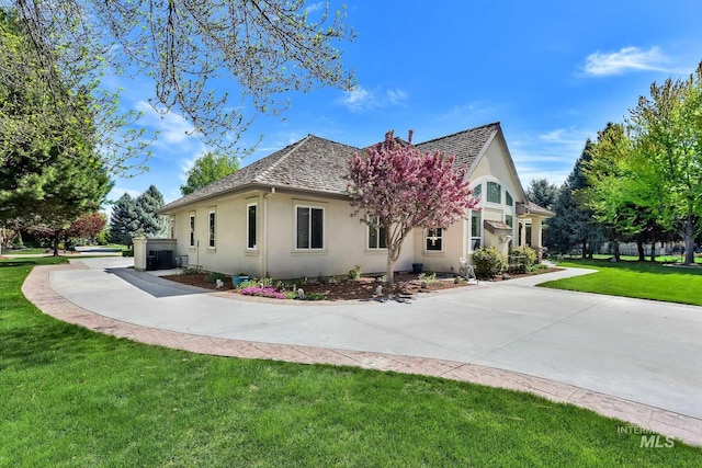 view of property exterior featuring a yard, central air condition unit, and stucco siding