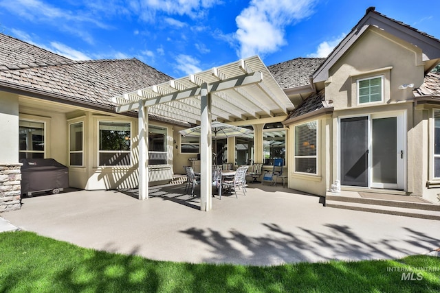 back of house with outdoor dining area, a pergola, stucco siding, and a patio area
