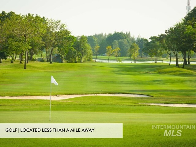 view of property's community with a water view, view of golf course, and a yard
