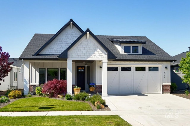 craftsman-style house featuring an attached garage, driveway, board and batten siding, a shingled roof, and brick siding