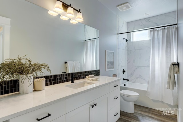full bath with wood finished floors, shower / tub combo, vanity, decorative backsplash, and toilet