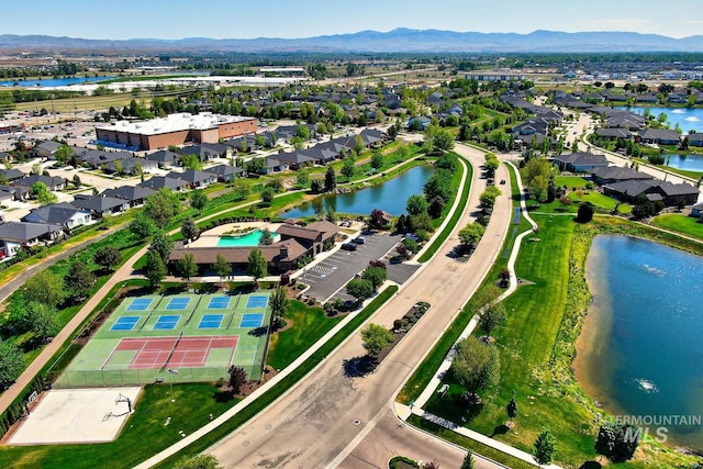 aerial view of property and surrounding area with a water and mountain view and nearby suburban area