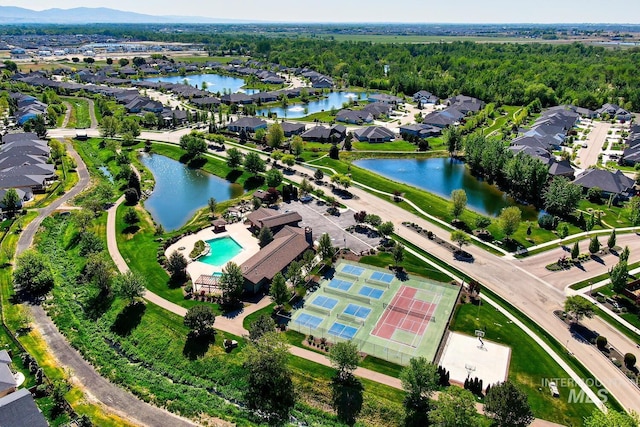 aerial overview of property's location featuring a large body of water, nearby suburban area, and a pool