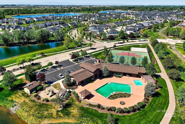 view of property location featuring a pool area, nearby suburban area, and a large body of water
