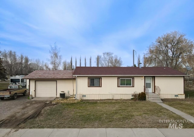 view of front of house with a front lawn, a garage, and central air condition unit