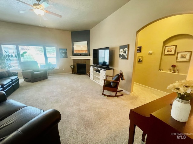 719 W Arbor Pointe, Nampa, ID 83686 - living room with arched walkways, light colored carpet, ceiling fan, a fireplace, and a textured ceiling