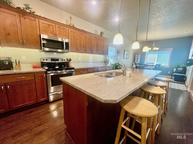 719 W Arbor Pointe, Nampa, ID 83686 - kitchen with appliances with stainless steel finishes, a kitchen bar, backsplash, hanging light fixtures, and an island with sink