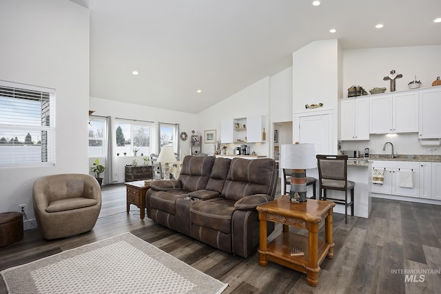 living area with high vaulted ceiling, dark wood-type flooring, and recessed lighting