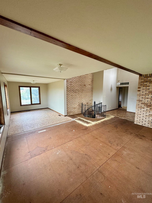 unfurnished living room featuring beam ceiling