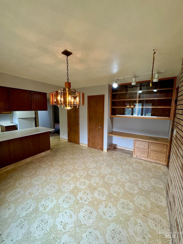 kitchen featuring an inviting chandelier, white refrigerator, decorative light fixtures, and track lighting