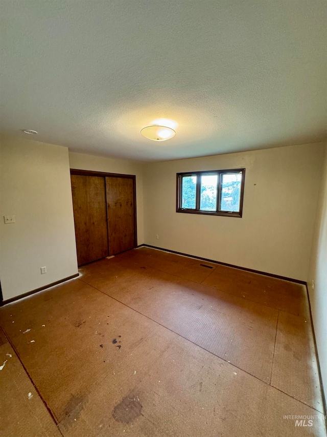 unfurnished bedroom with a textured ceiling and a closet