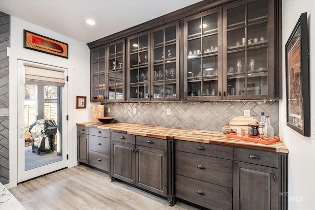 bar featuring decorative backsplash and dark brown cabinets