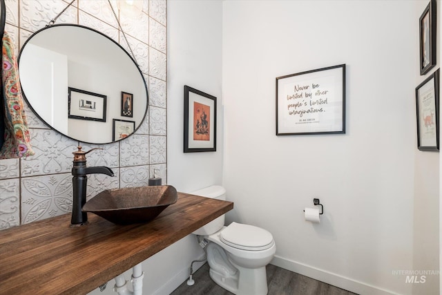 bathroom featuring hardwood / wood-style flooring, sink, and toilet