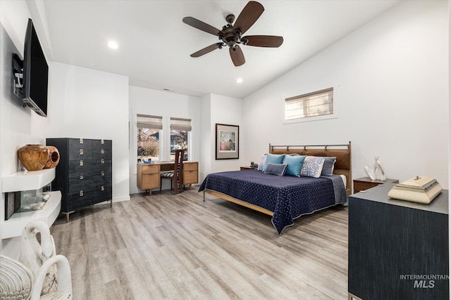 bedroom with ceiling fan, light hardwood / wood-style flooring, and lofted ceiling