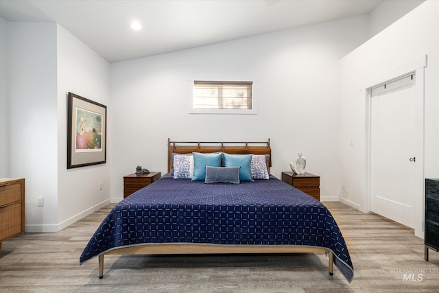 bedroom featuring lofted ceiling and light hardwood / wood-style flooring