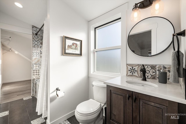 bathroom featuring vaulted ceiling, toilet, and vanity