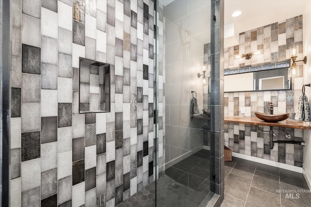 bathroom featuring sink, tile walls, tiled shower, and tile patterned flooring