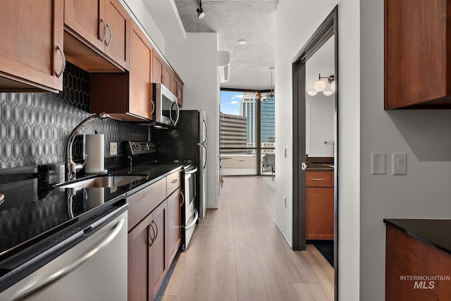 851 W Front St Unit 607, Boise, ID 83702 - kitchen with stainless steel appliances, a sink, backsplash, light wood finished floors, and floor to ceiling windows