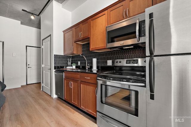 851 W Front St Unit 607, Boise, ID 83702 - kitchen with stainless steel appliances, dark countertops, light wood-style floors, tasteful backsplash, and brown cabinetry