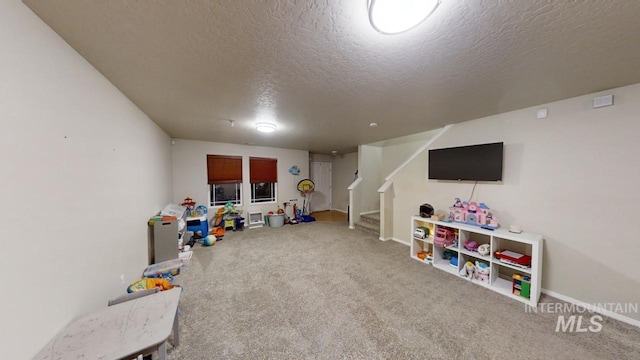 playroom with a textured ceiling and carpet