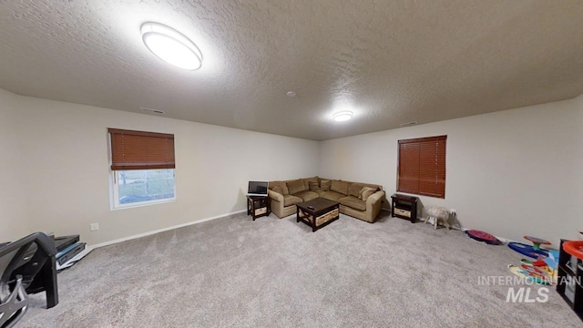 unfurnished living room featuring a textured ceiling and carpet floors