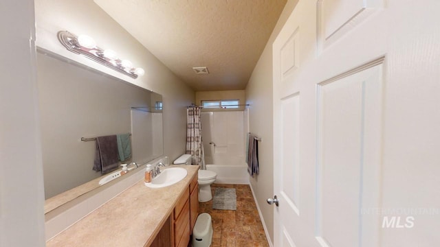 full bathroom featuring shower / bath combo with shower curtain, a textured ceiling, toilet, and vanity