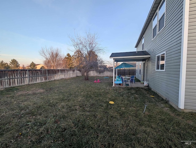 yard at dusk featuring a patio area