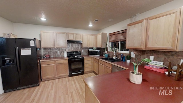 kitchen featuring light hardwood / wood-style floors, backsplash, light brown cabinets, black appliances, and sink