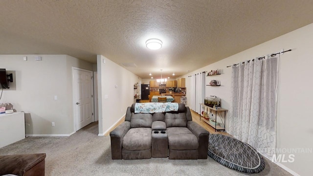 sitting room with a textured ceiling and carpet flooring