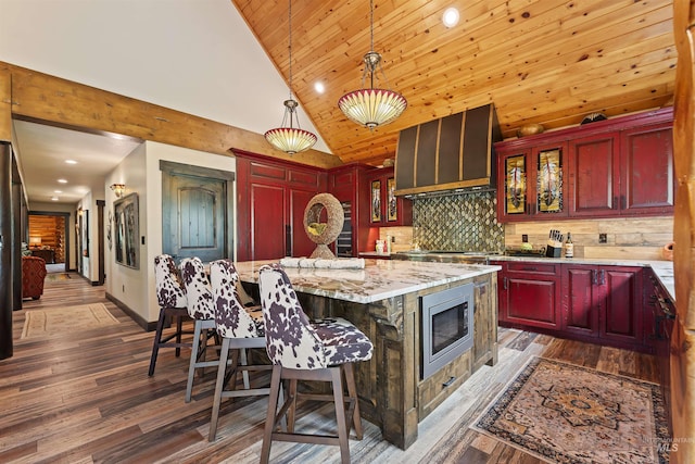 14051 Deerfield Rd, Mccall, ID 83638 - kitchen with stainless steel microwave, extractor fan, reddish brown cabinets, lofted ceiling, and recessed lighting