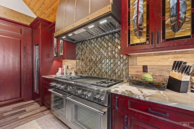 14051 Deerfield Rd, Mccall, ID 83638 - kitchen with range with two ovens, under cabinet range hood, backsplash, reddish brown cabinets, and lofted ceiling
