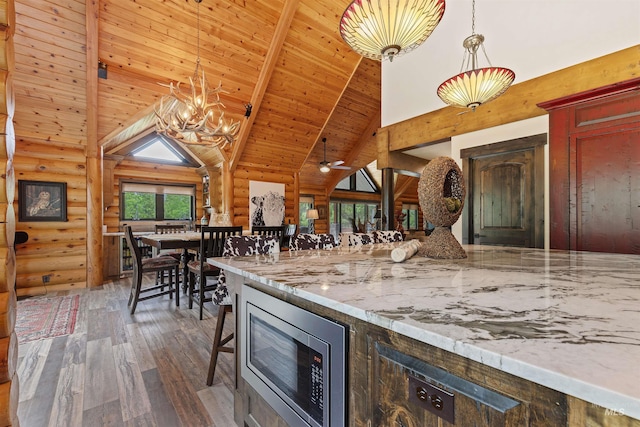 14051 Deerfield Rd, Mccall, ID 83638 - kitchen featuring stainless steel microwave, log walls, high vaulted ceiling, wood-type flooring, and a wood ceiling with exposed beams