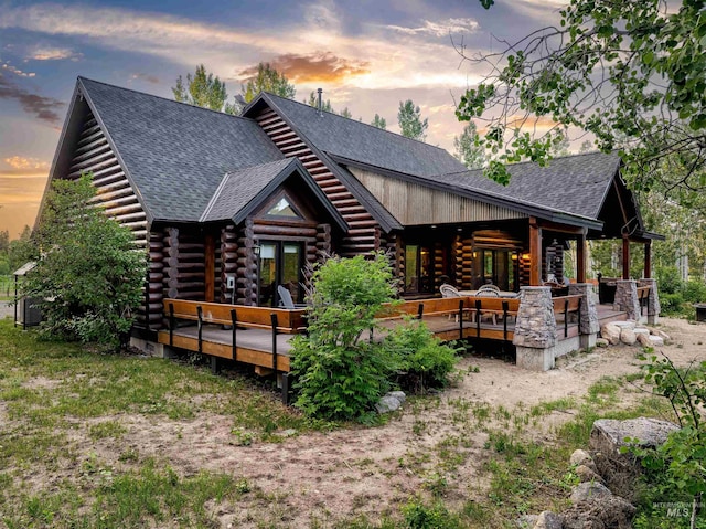 14051 Deerfield Rd, Mccall, ID 83638 - back of house at dusk featuring log exterior, a shingled roof, and a deck