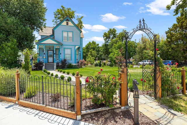 victorian house featuring a front yard and a fenced front yard