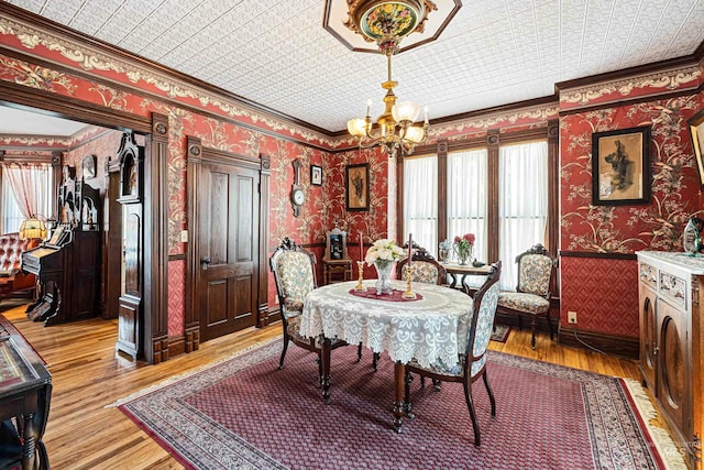 dining room featuring crown molding, a healthy amount of sunlight, and light hardwood / wood-style flooring