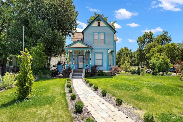 victorian house featuring a front yard and covered porch