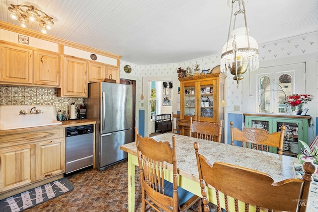 kitchen with an inviting chandelier, plenty of natural light, stainless steel appliances, and sink