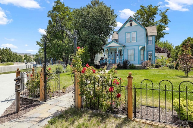 victorian home featuring a fenced front yard and a front yard