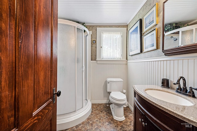 bathroom with vanity, toilet, and a shower with door