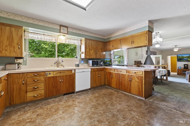 93 S Lancaster Dr, Nampa, ID 83651 - kitchen featuring white dishwasher, a sink, brown cabinetry, a peninsula, and light countertops