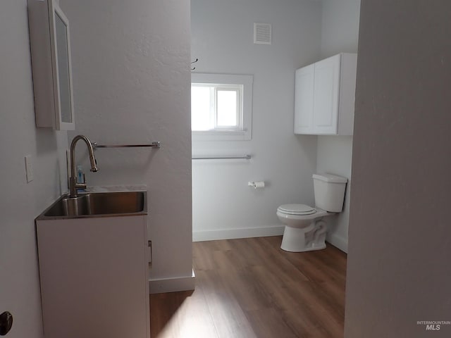 bathroom featuring wood-type flooring, vanity, and toilet