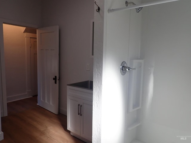 bathroom with a shower, hardwood / wood-style floors, and vanity